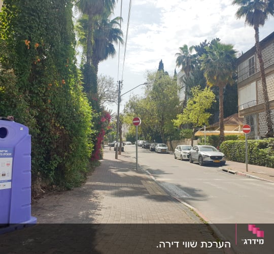 מיכל מיחזור סגול ברחוב עם מכוניות חונות